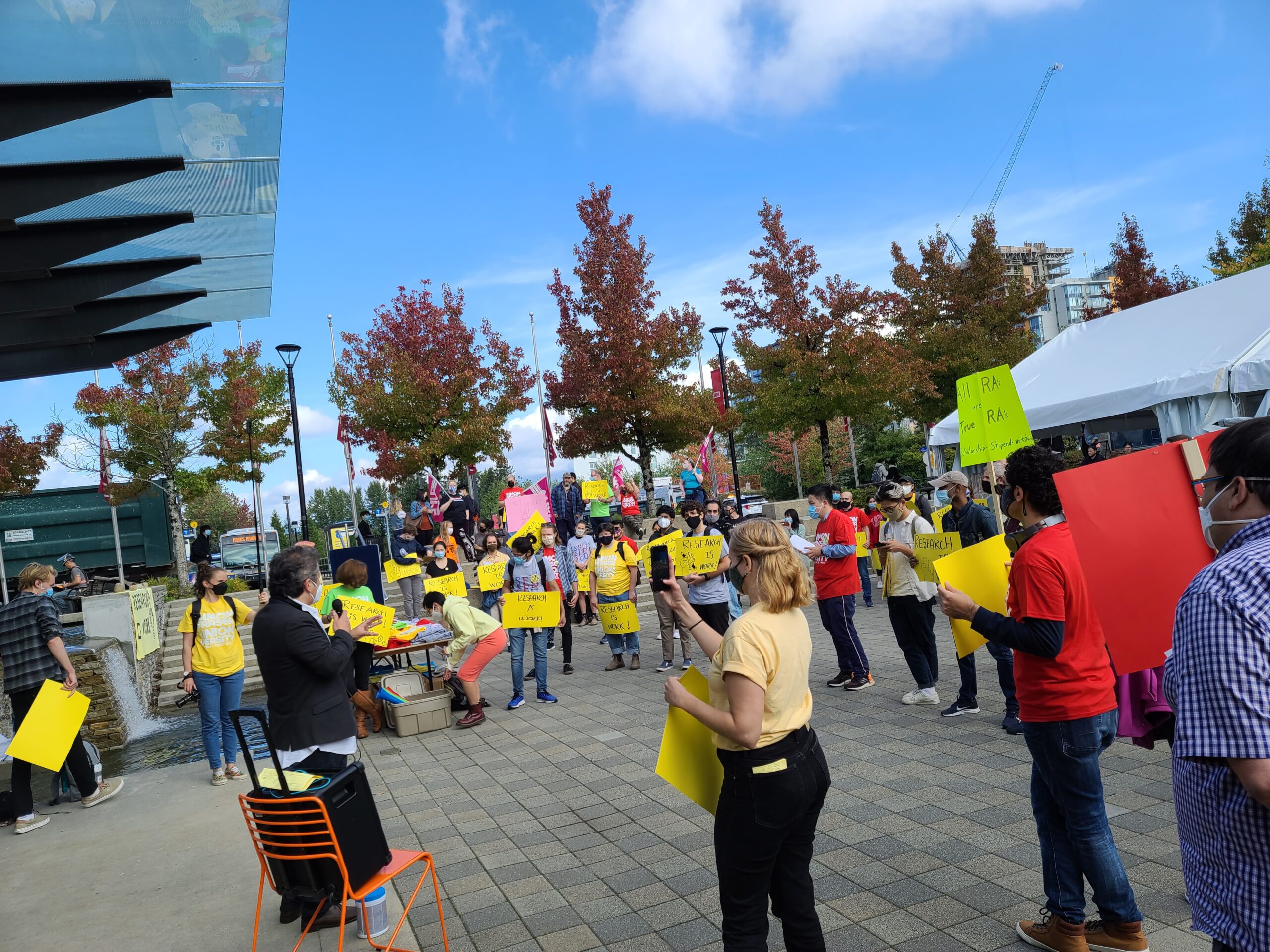 People wearing yellow shirts holding signs in protest