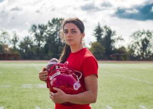 Kristie Elliot holding helmet and football
