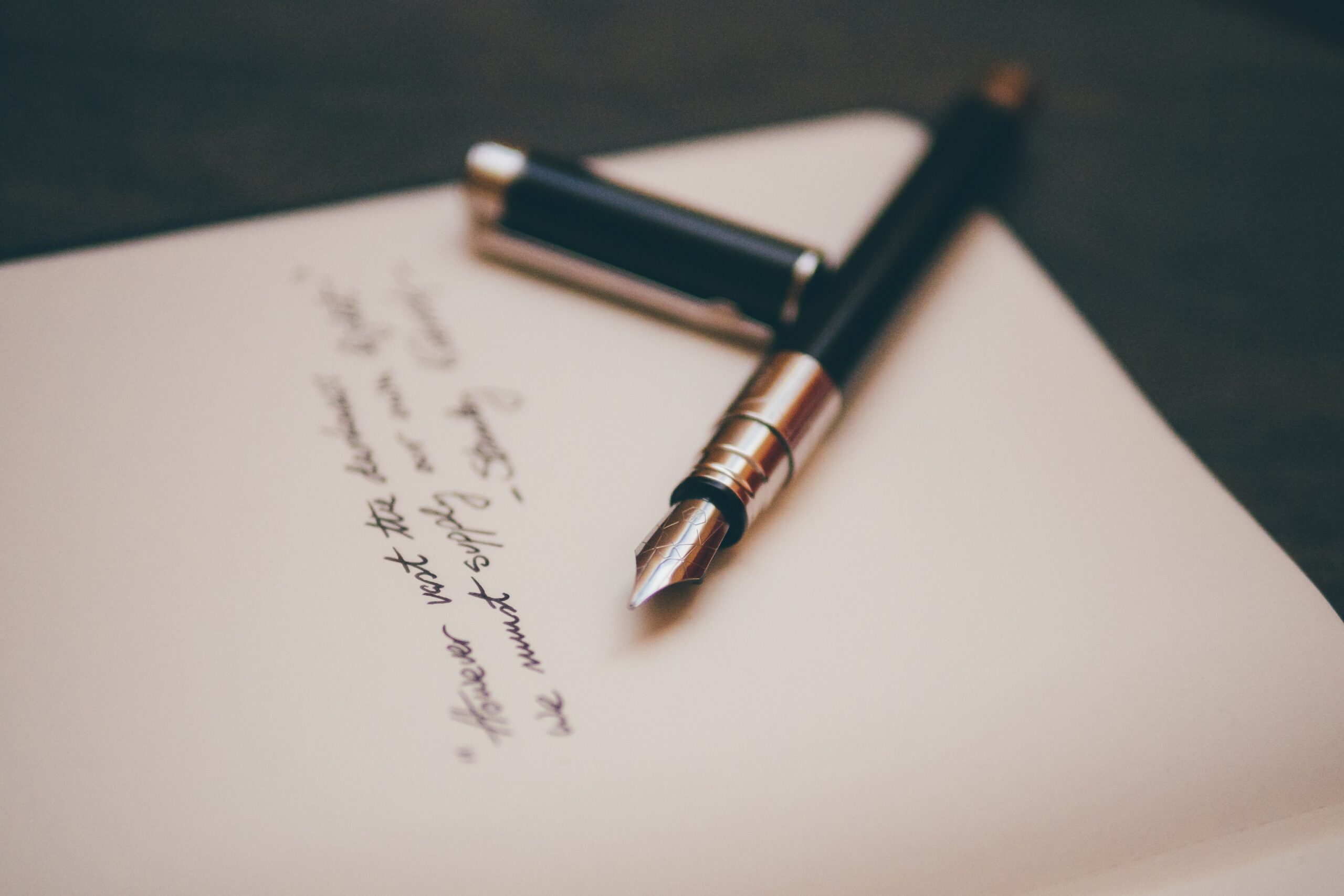 a fountain pen on paper with cursive writing
