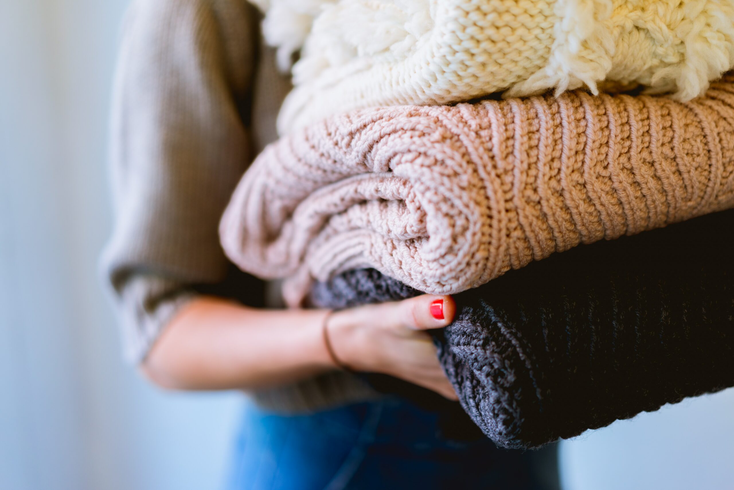 Three knitted article of clothing stacked on top of each other