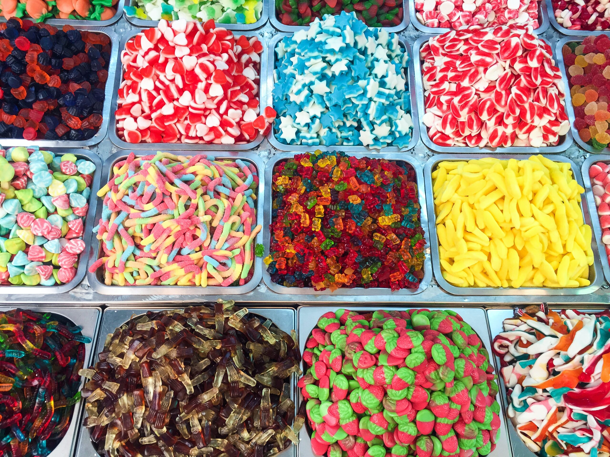 Candies, in a variety of colours and shapes, in inset silver trays filled to the brim