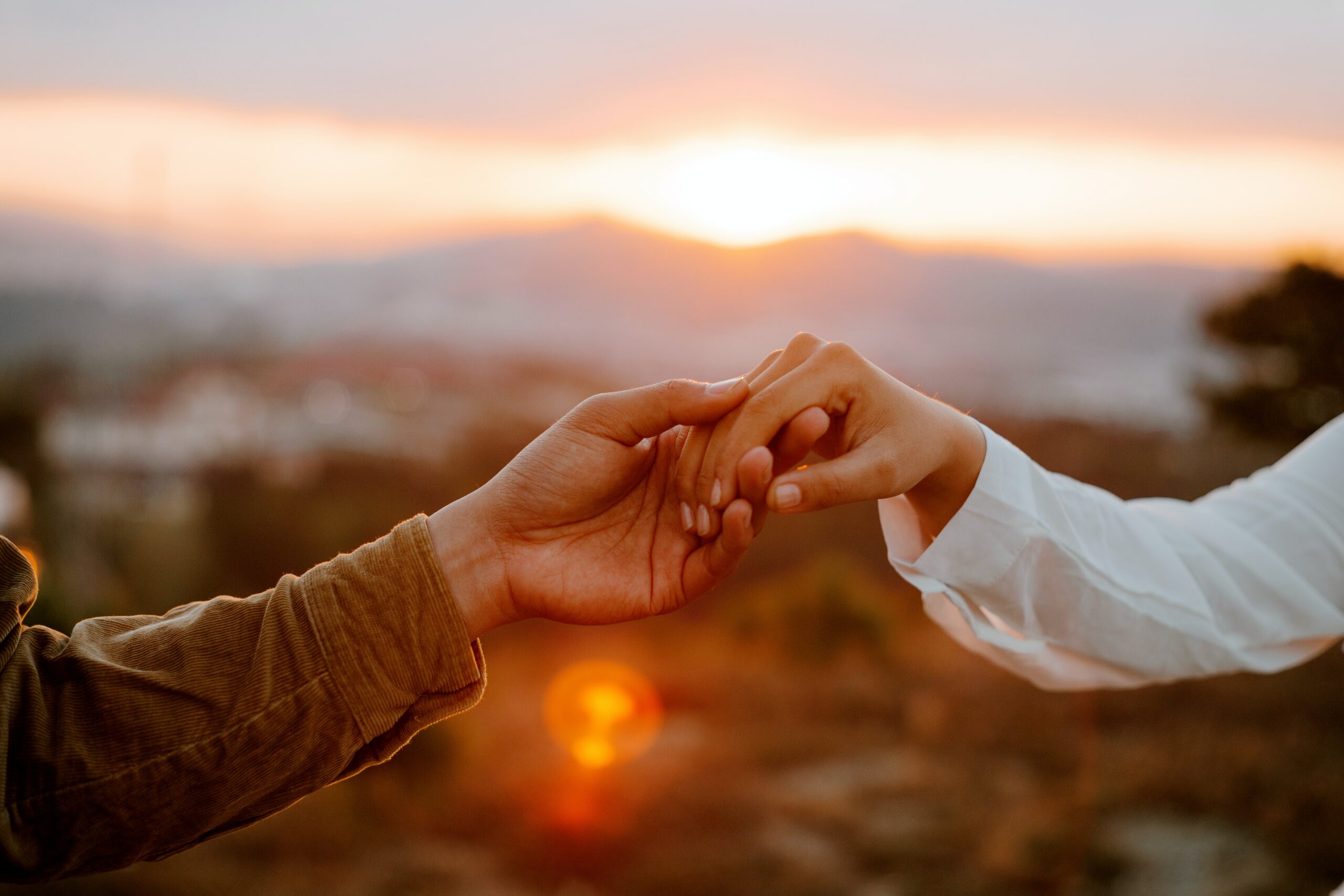 hand holding in front of sunset