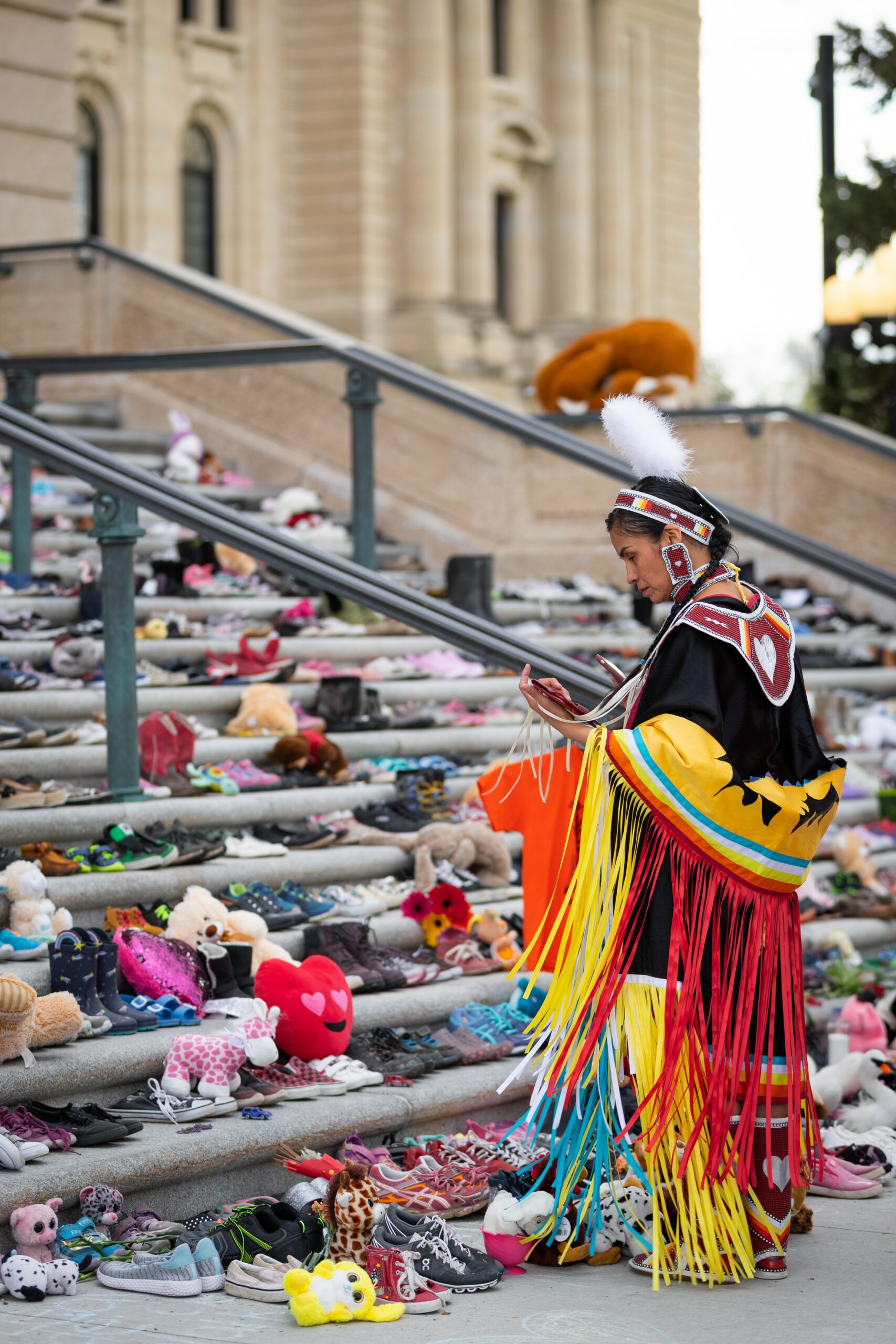 Person in Indigenous garment looking at items laid on staircase
