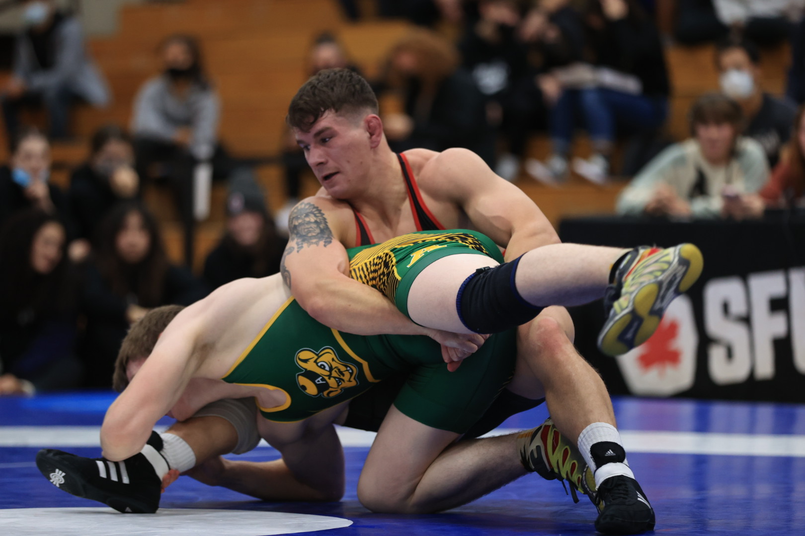 Logan Nelson grapples an opponent on the floor, with his arms locked around their leg.