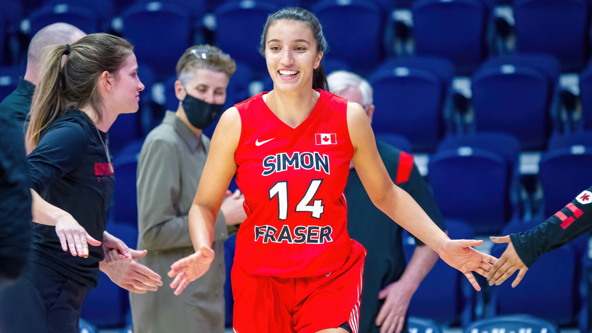 Jessica Wisotzki smiles as she walks out to the court in between staff members while giving them low fives.