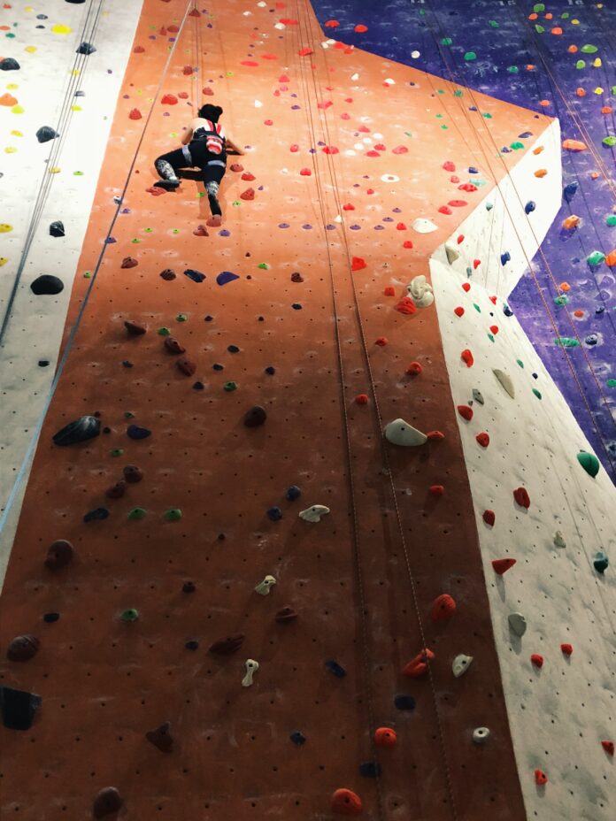 Week 6 Facing a wall Article (2) Photo shot looking up at a climber scaling the wall.