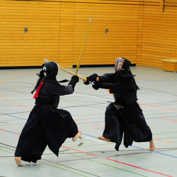 b-vi-KO3ywBQo5IU-unsplash (2) Two people engage in a battle in full armour, wielding their sword.