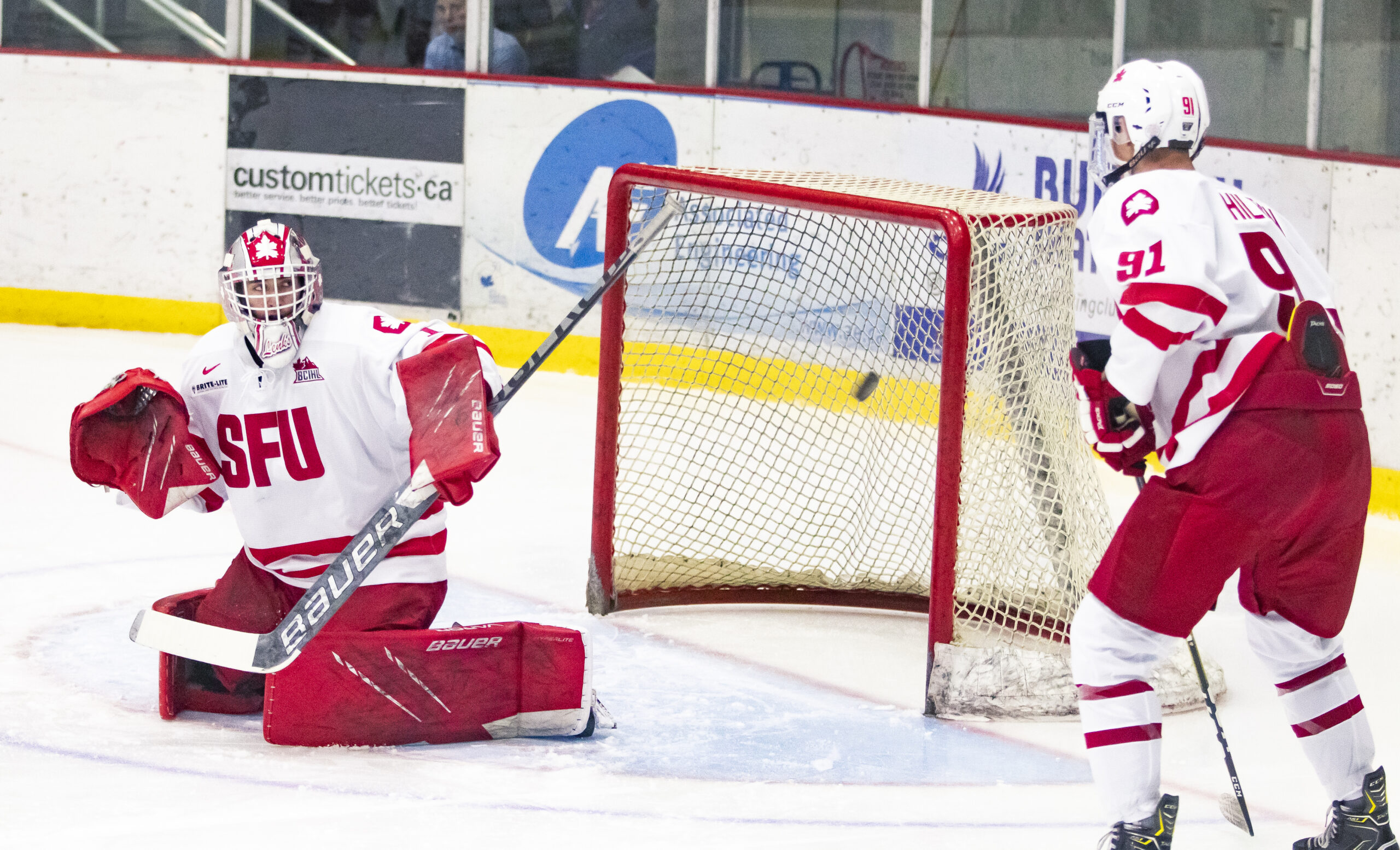 A photo of SFU goaltender Michael Lenko making a blocker save during warmups.