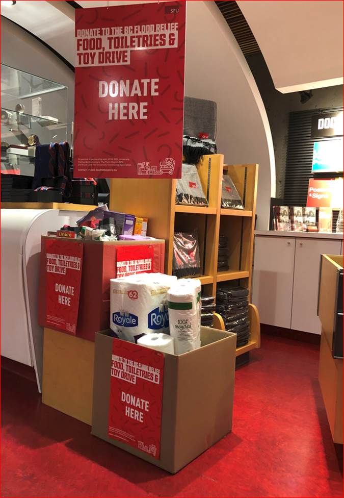 Donation boxes stacked on top of each other with a “DONATE HERE” sign on top