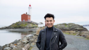 Huang smiling with a lighthouse in the background