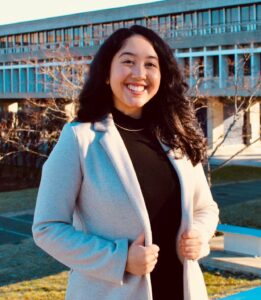 A full body shot of Pahou smiling in front of the AQ