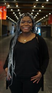 A full body shot of Priebe smiling inside of the AQ