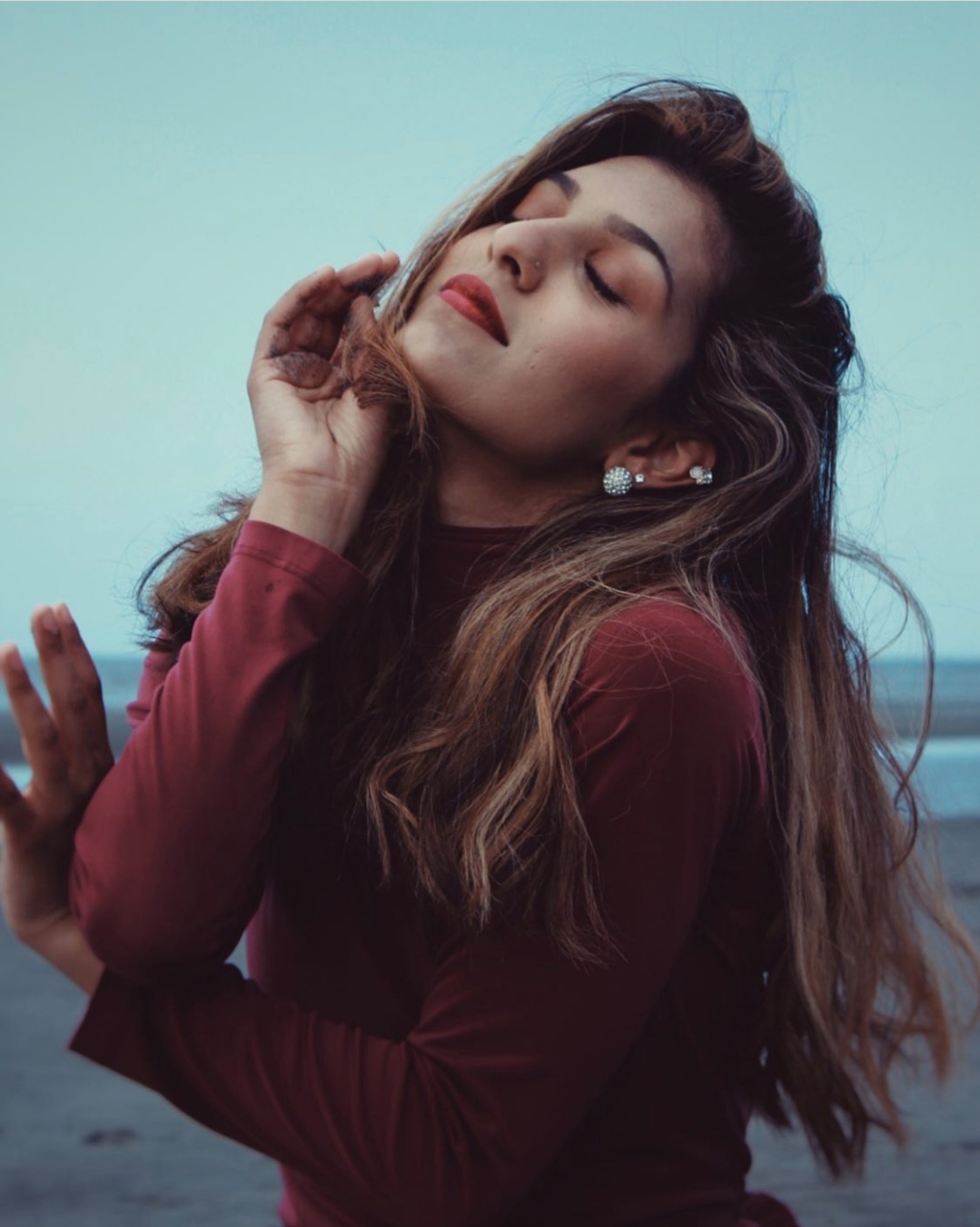 Portrait of Roya at the beach with her eyes closed and head tilted up