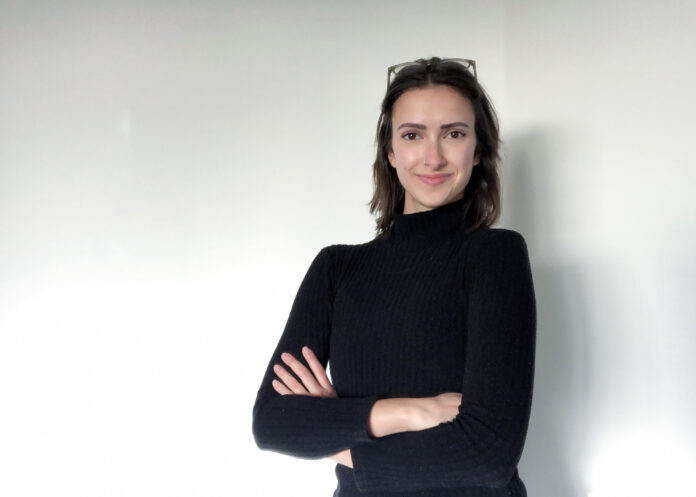 A woman standing with her arms crossed looking smug