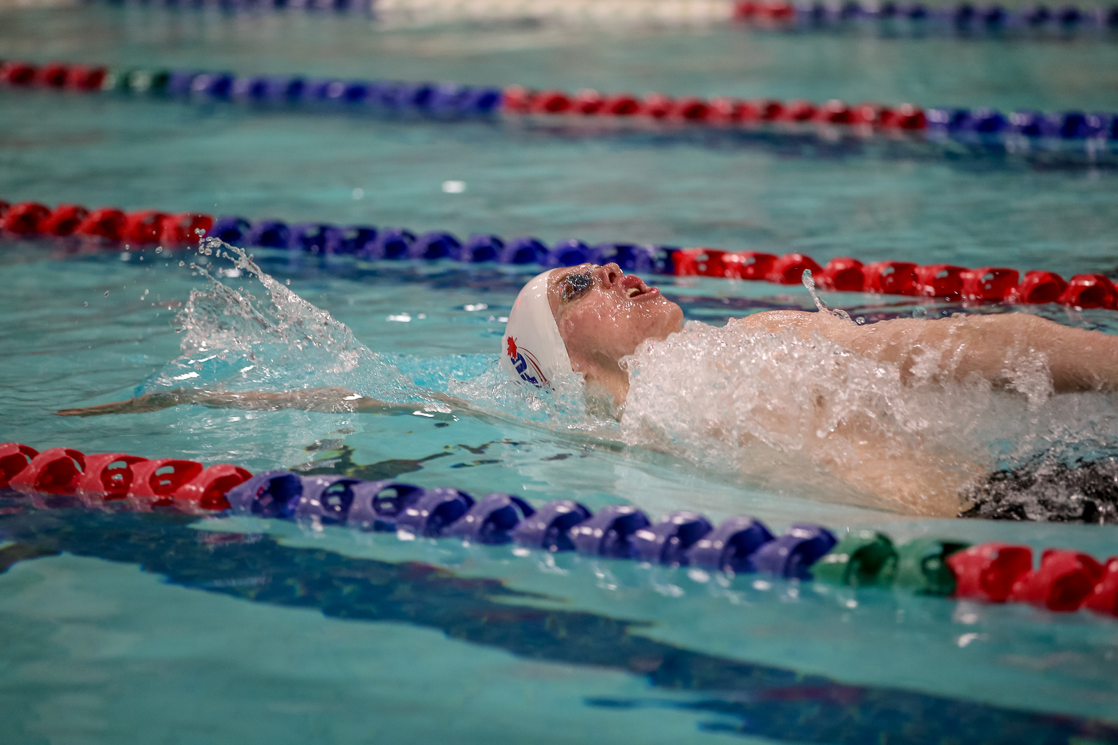 SFU swimmer Jayden Cole pictured in the water performing a backstroke.