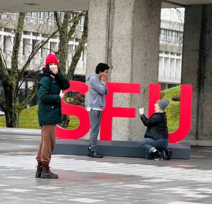 0dc28d86741ee4cb5c45e0ea8f4e1358 a person proposes to another while an onlooker gasps