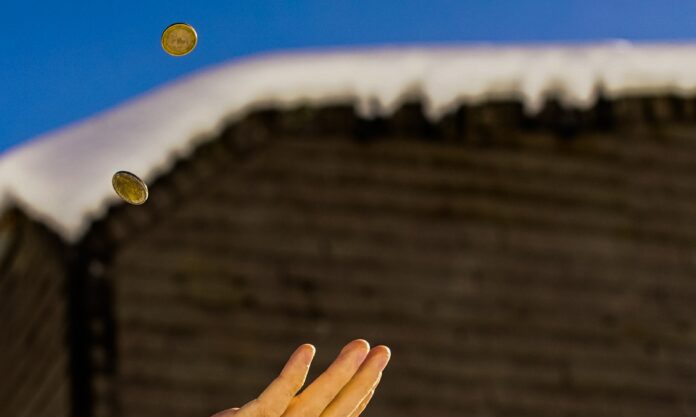 A few coins are being thrown in the air. The backdrop is blurred.