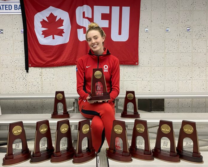 SFU swimmer Kayleigh Sharkey posing with her 11 trophies