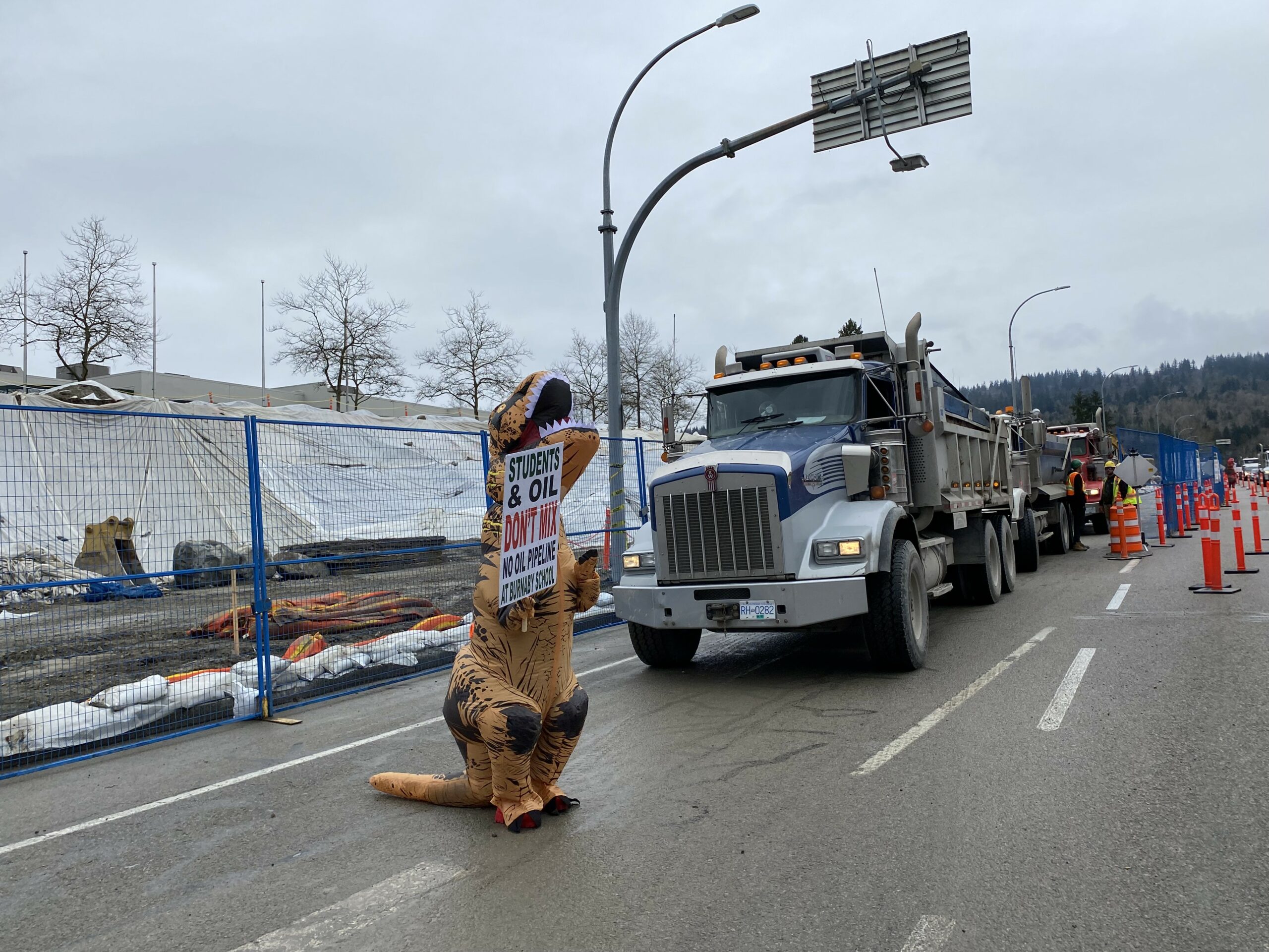 a costume dinosaur blocking a truck