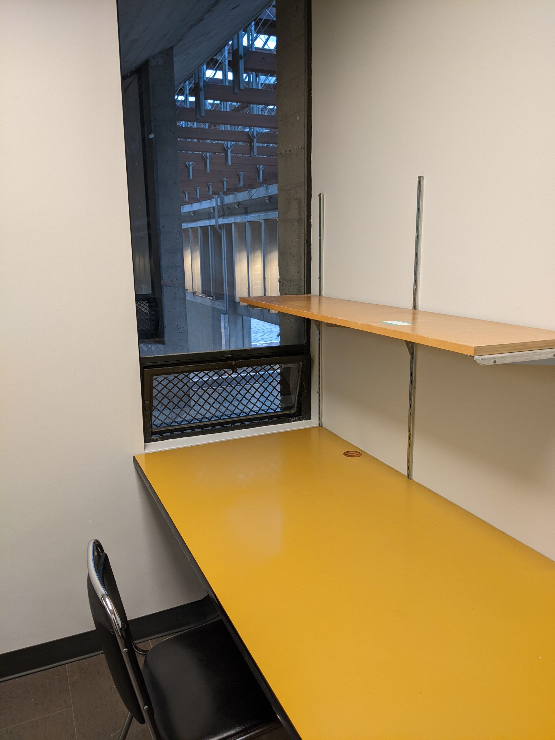 A study room, as described in the piece. The table is broad, and a window looks out from the side of the room.