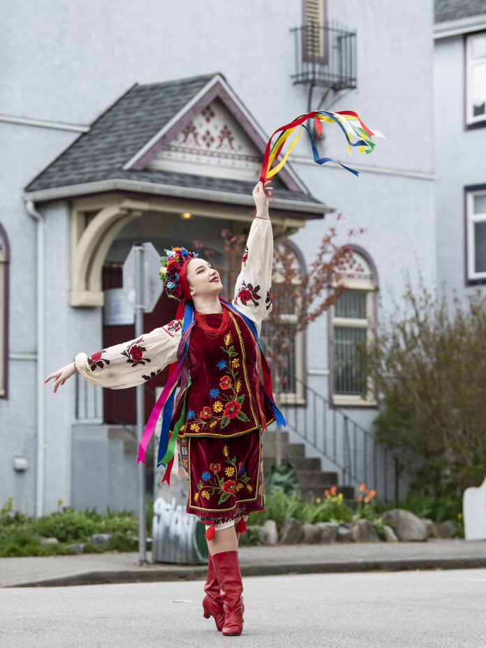 Dovbushdancers_photocredTallulah A young Ukrainian dancer is pictured in her colourful traditional dance costume in front of the Vancouver Ukraine Cultural Centre building