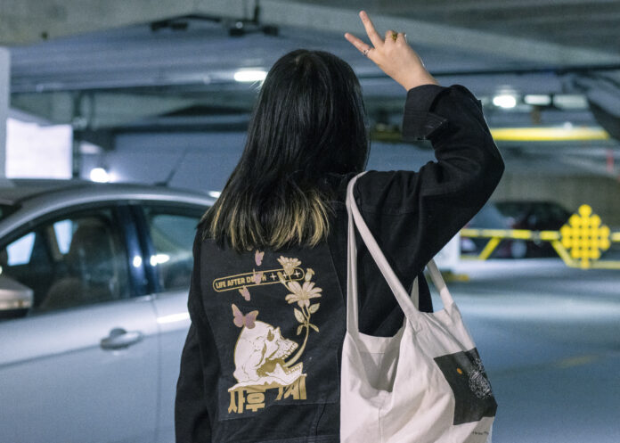 best_parking_lots A photo of a student posing in front of a parking lot, holding up a peace sign