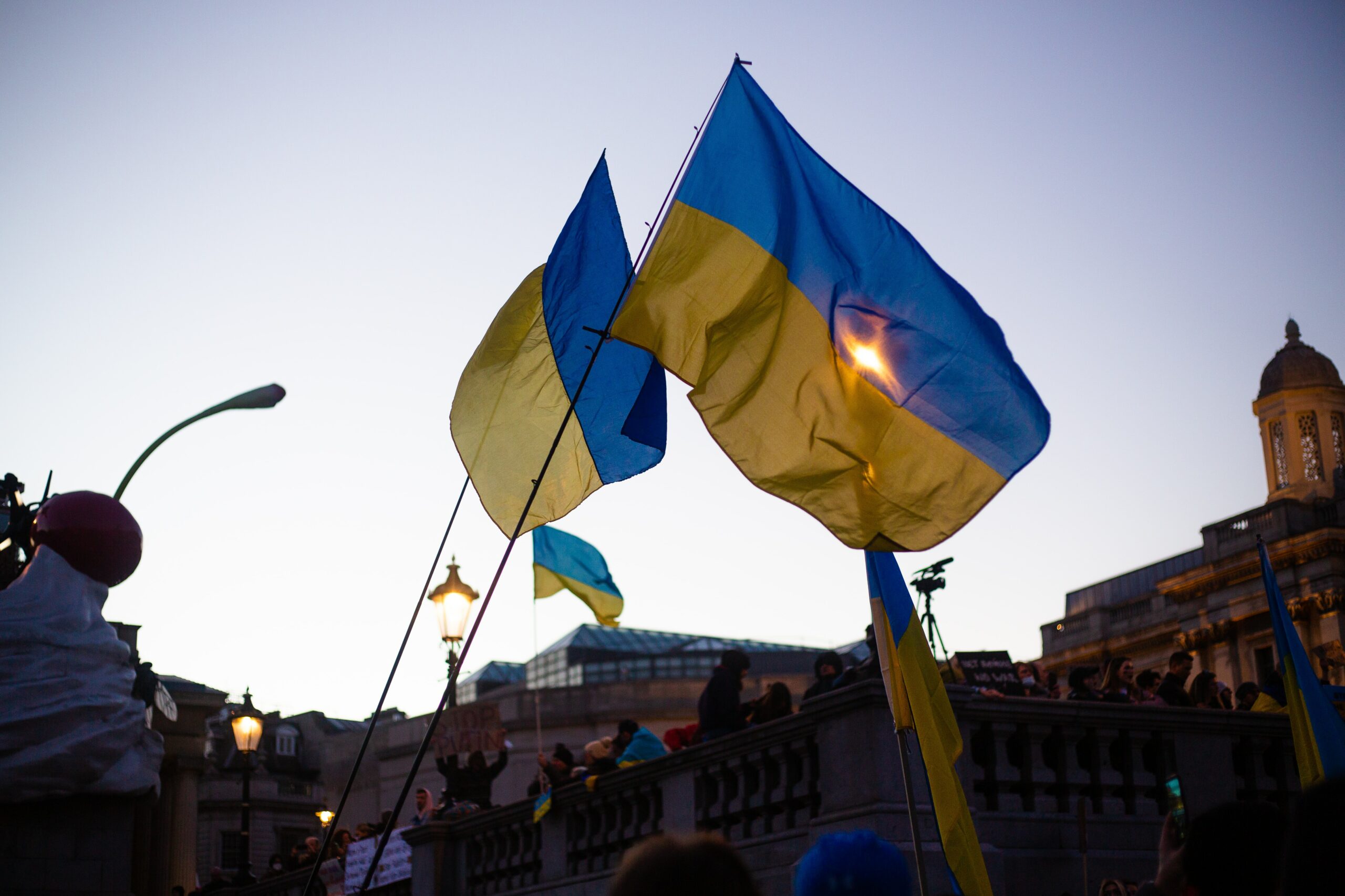Two Ukrainian flags are being lifted into the sky.