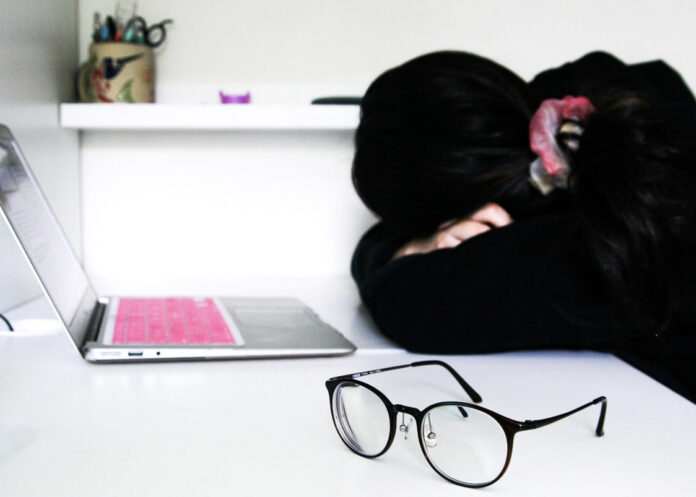 Professionally-dressed woman in black and white visibly struggling with mental health