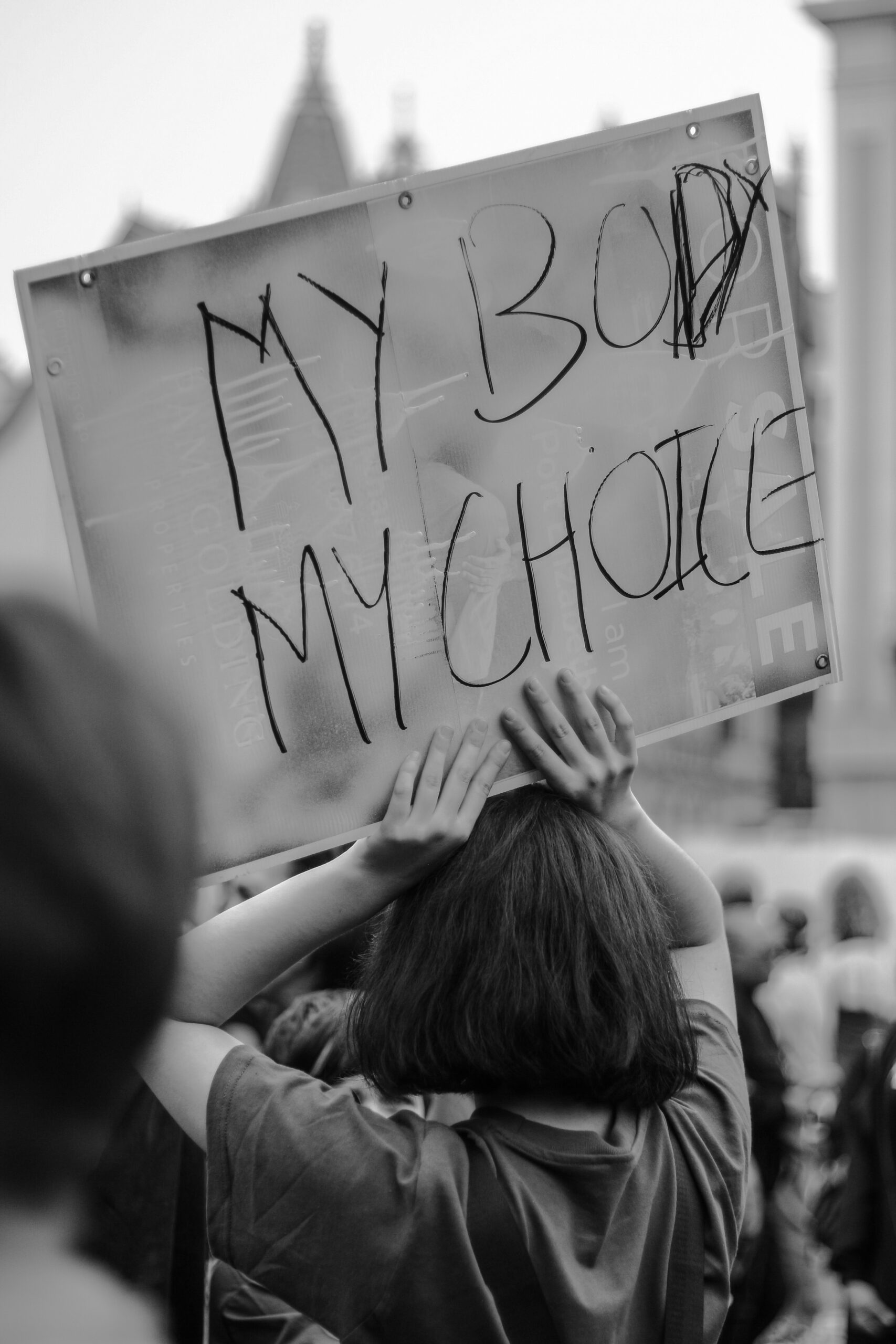black and white photo of a pro-abortion protestor holding a sign that says “my body, my choice.”