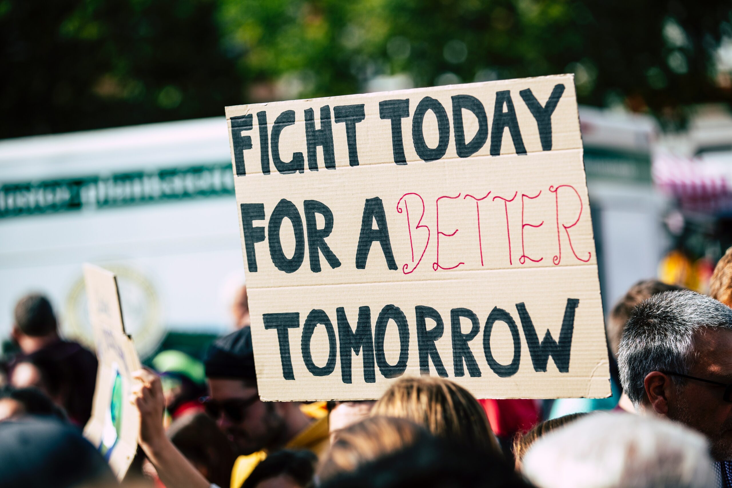 picture of a climate rally framed around a sign that reads “fight today for a better tomorrow”