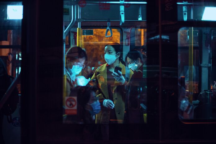 pexels-zydeaosika-3960076 People masked up on the bus at night