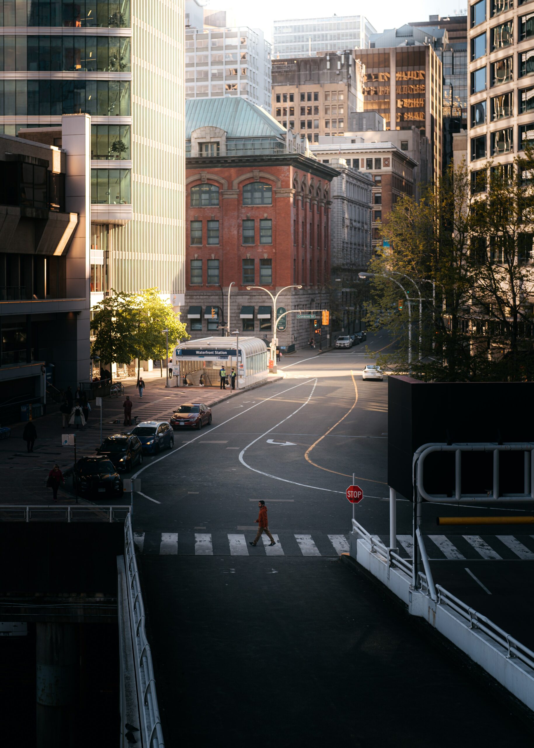 The photo is of the streets of Vancouver. The street is empty except for one individual crossing the street.