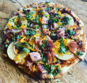 Thin crust pizza pictured on a wooden table