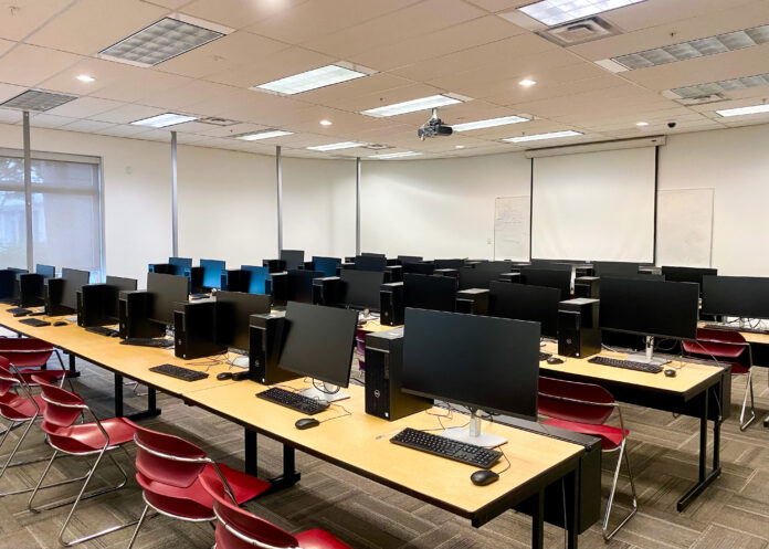 digital_democracy_institute The photo is of the SFU computer lab. Rows of computers fill the room. The room has no people and the computers are all turned off.