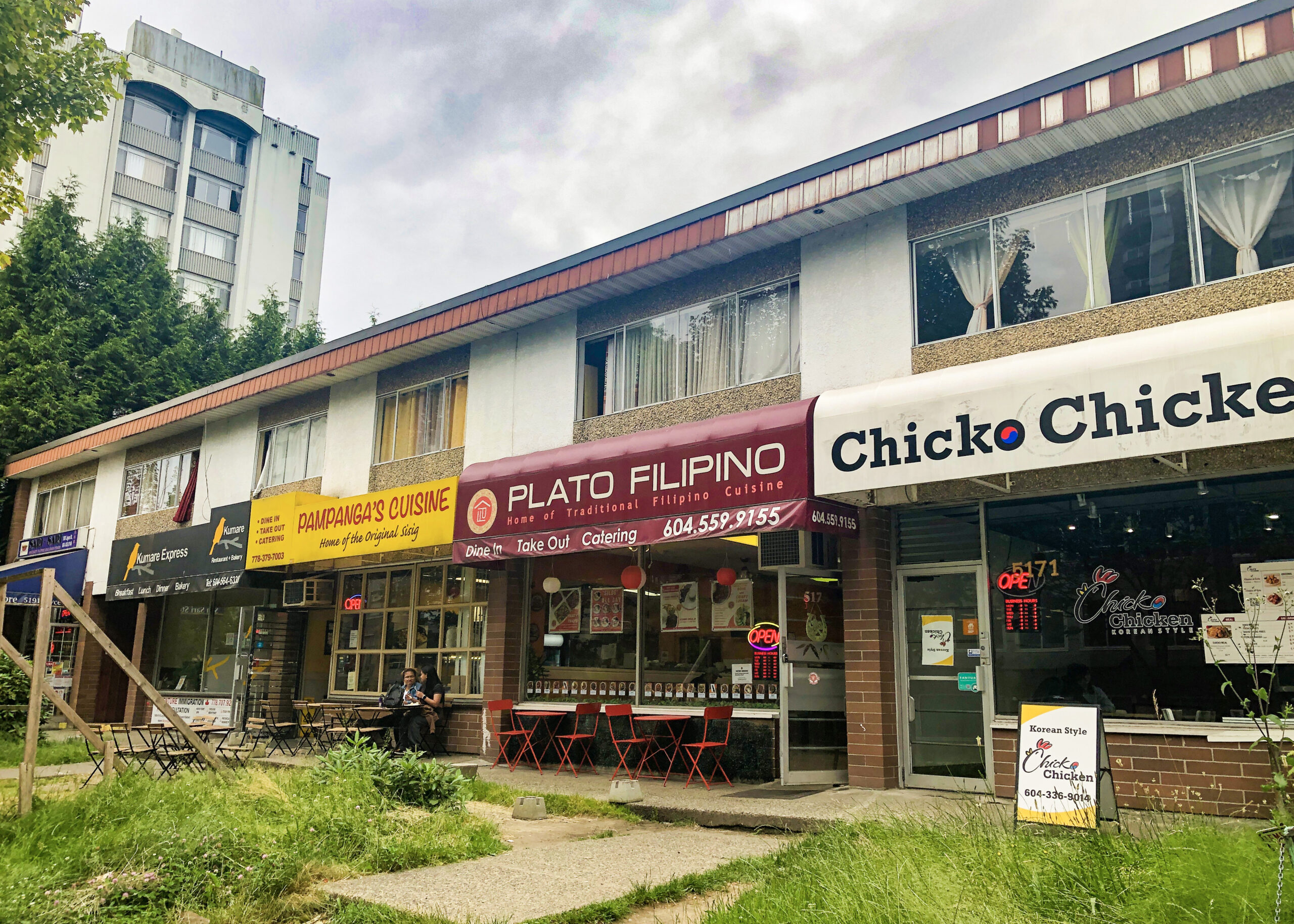 The photo is of the businesses on Joyce Street. Plato Filipino's store front is featured.