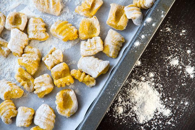 Homemade gnocchi being prepared on a baking sheet