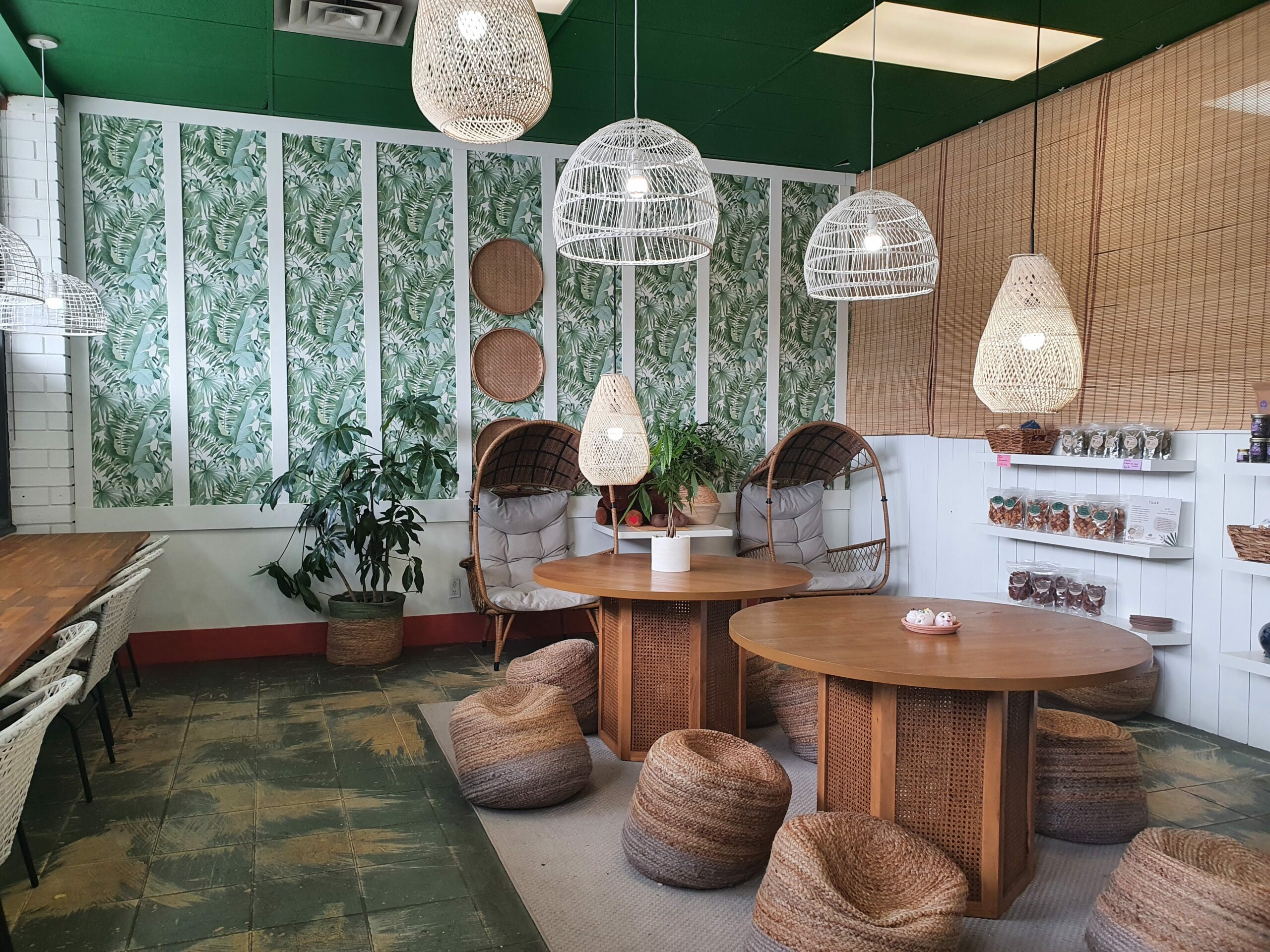 Kanadell’s new storefront interior, themed with green foliage and wick furniture