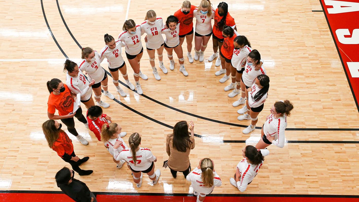 Photo of the SFU volleyball team in a huddle.