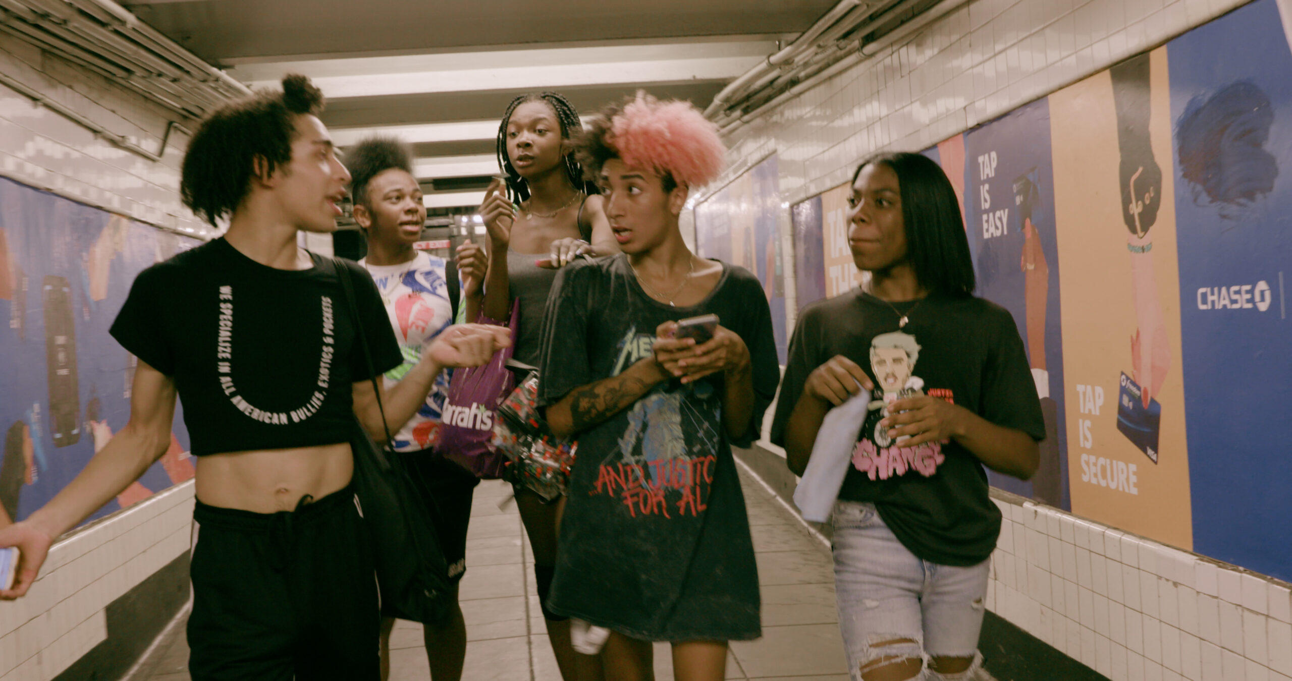 A group of Black queer youth walking down a subway station