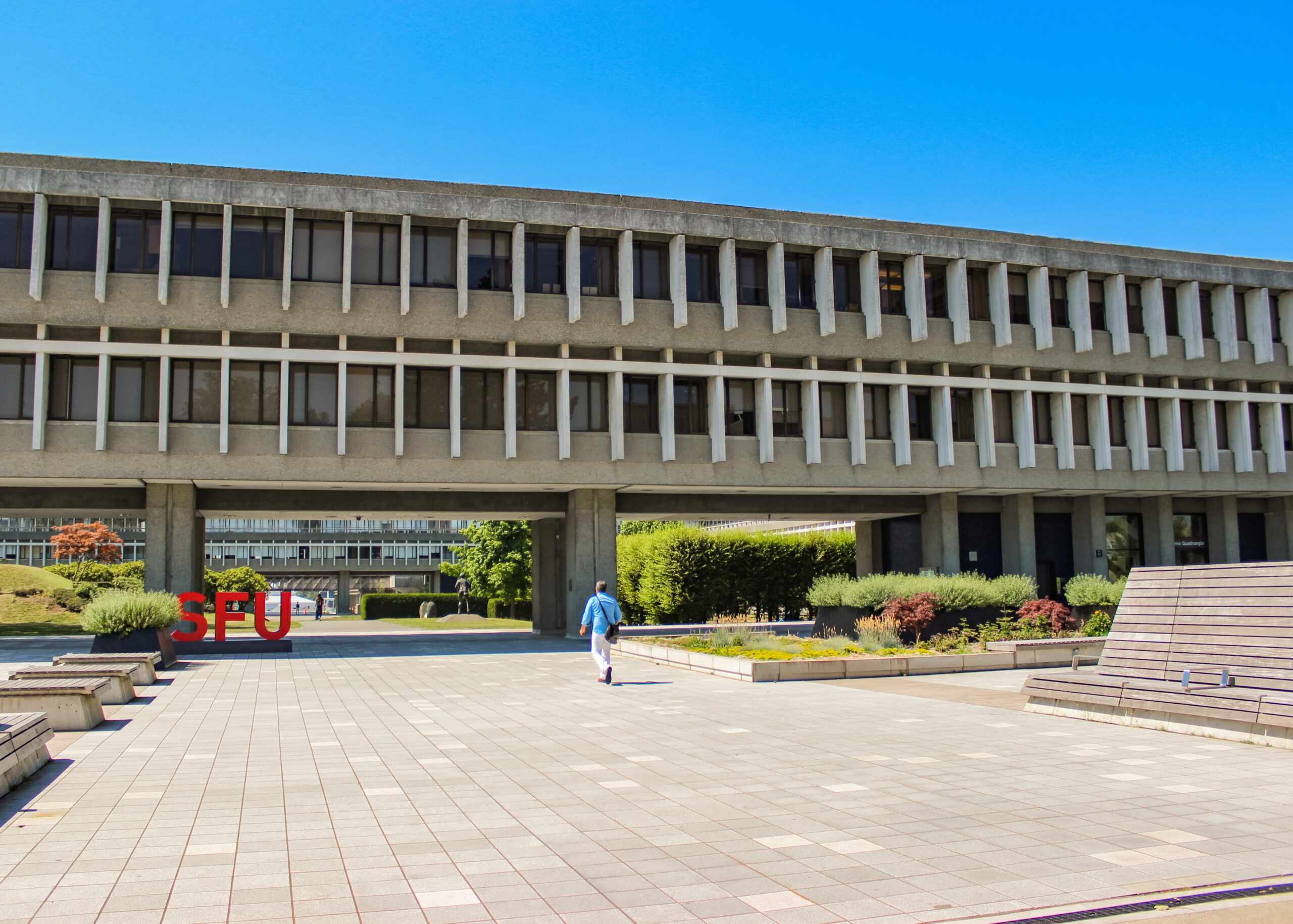 someone walking in front of SFU's academic quadrangle