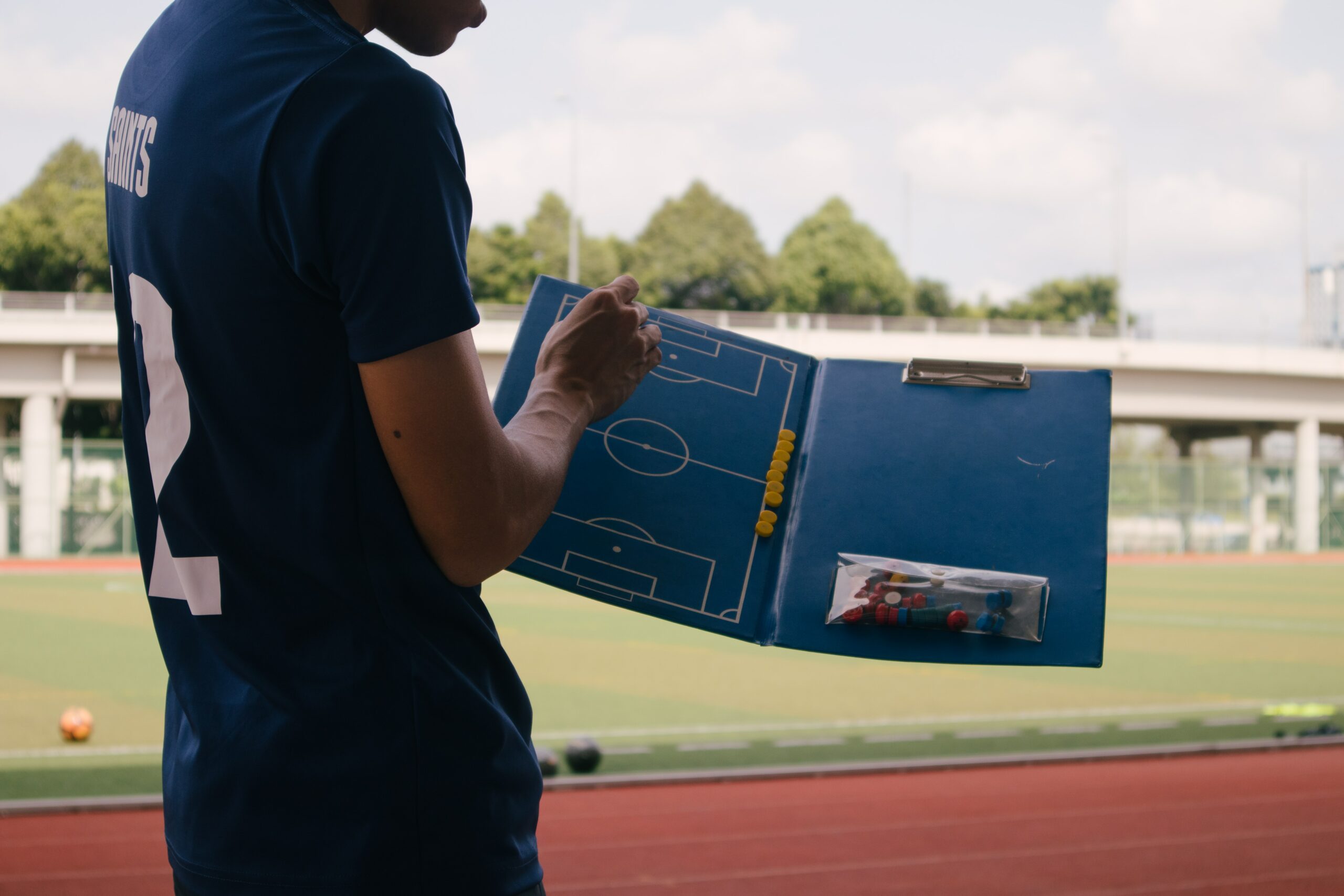 Photo of a soccer coach explaining something with his coaching board