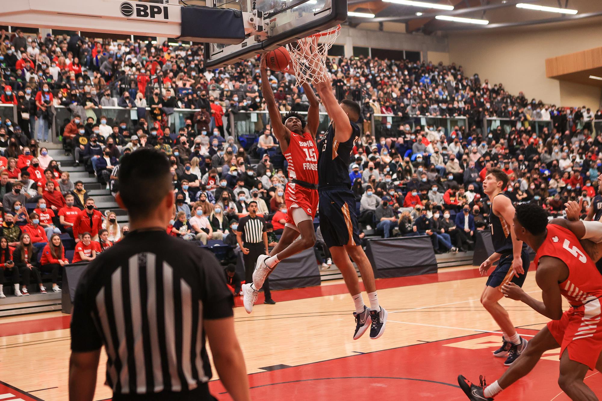 photo of Jahmal Wright dunking over a ball in a game.