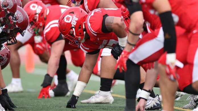 up close shot of players setting up on the line of scrimmage.