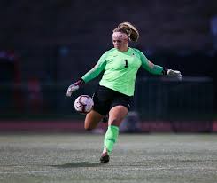 photo of Kelsey Fisher kicking a ball mid-game.