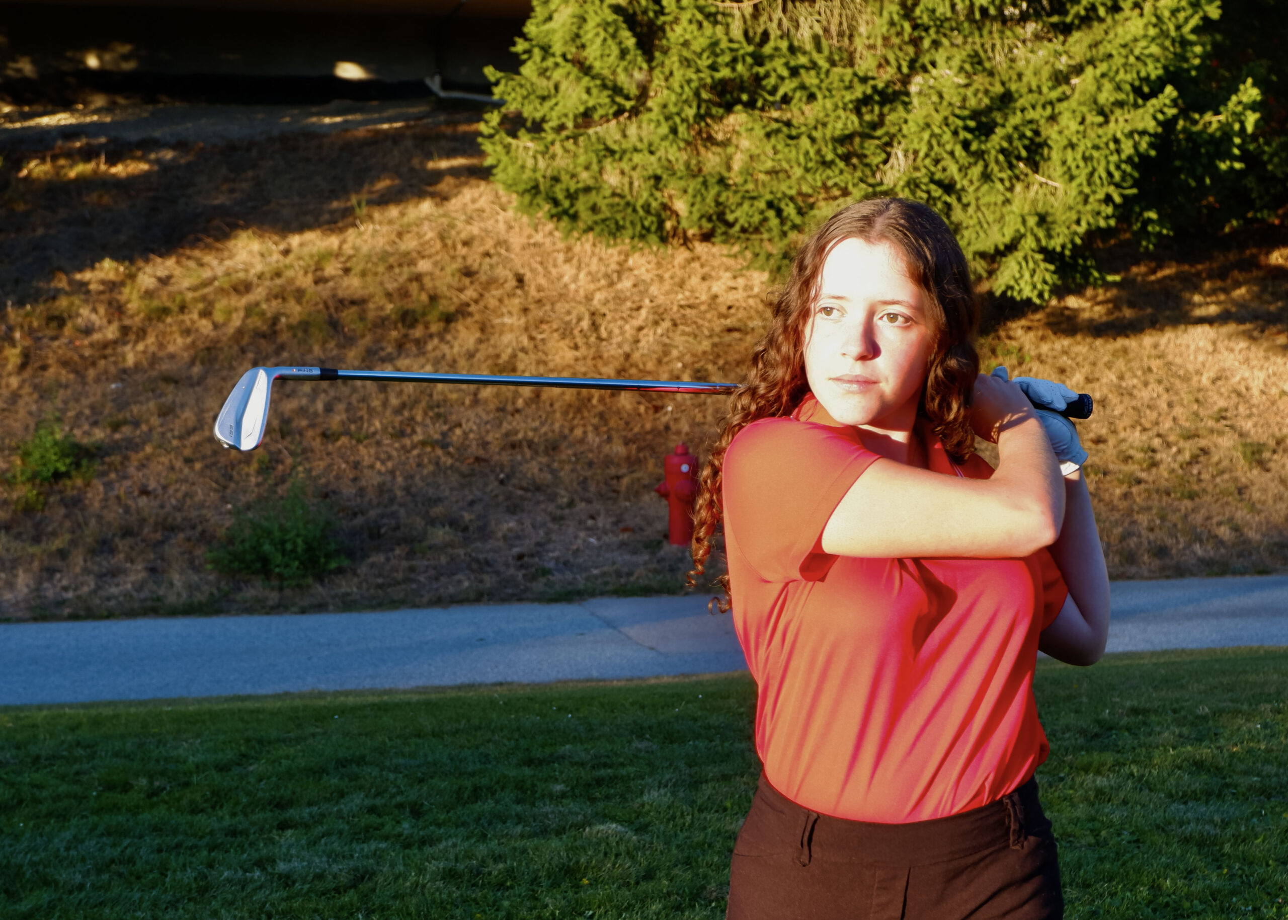 photo of Izzy Ferguson posed in her backswing after hitting a shot.