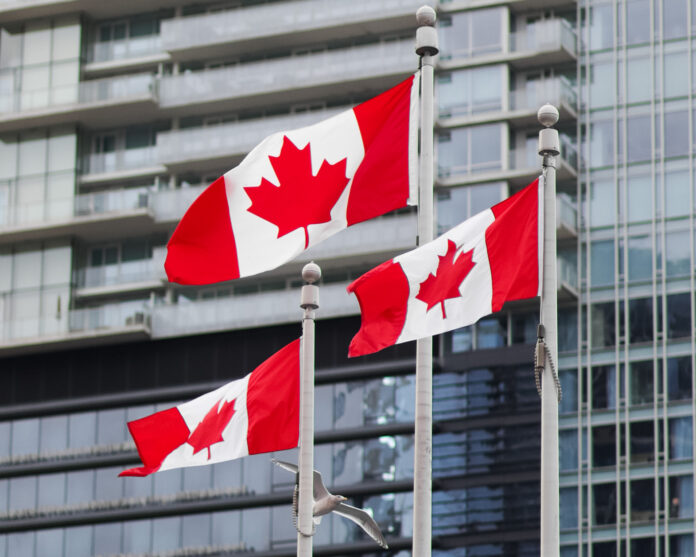 bc-name-change multiple Canadian flags on flagpoles