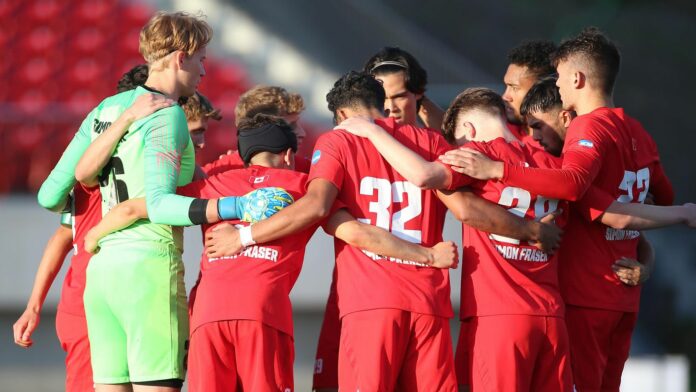 horizontal shot of the men’s soccer team in a huddle pre-game.