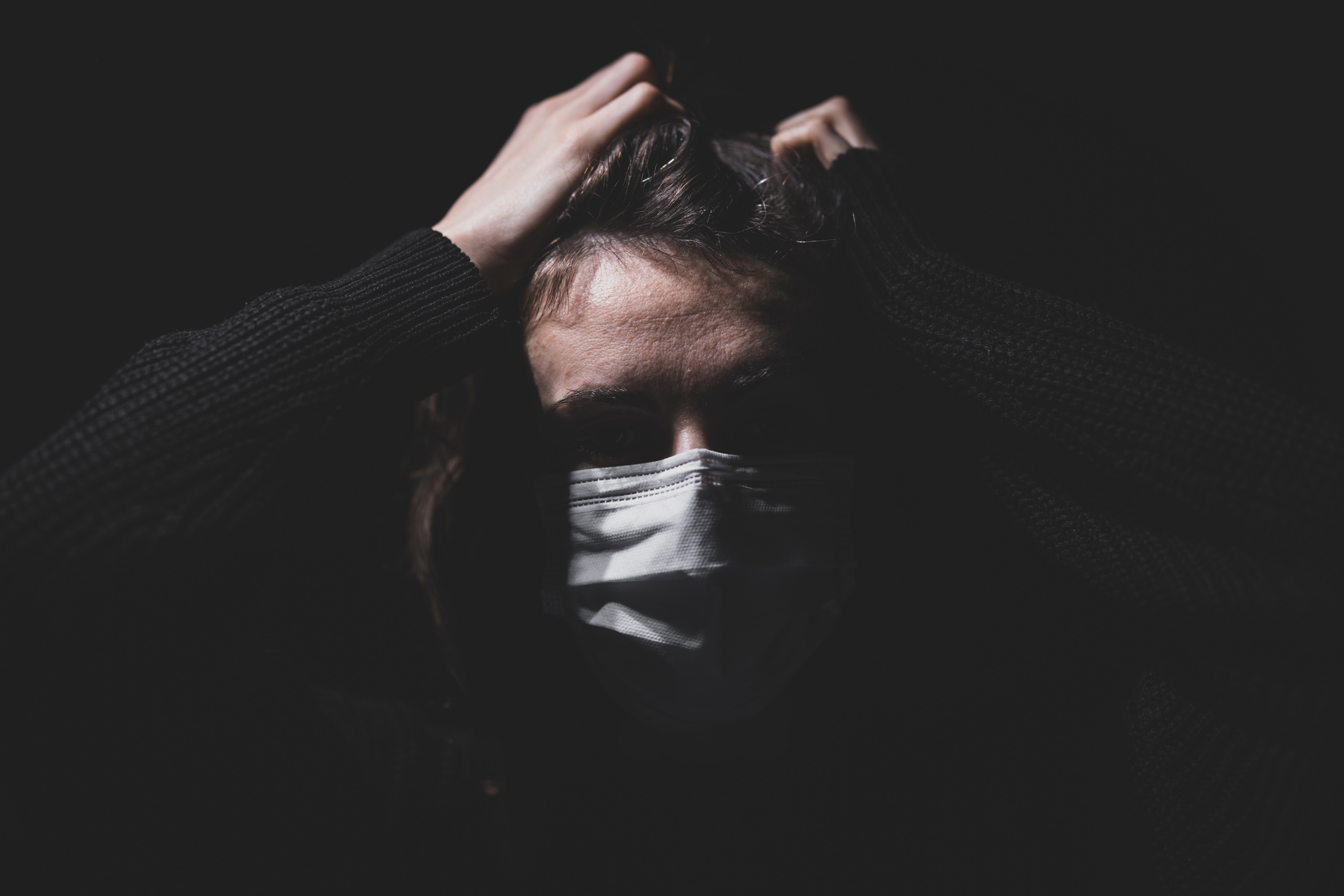 someone wearing a mask against a dark background