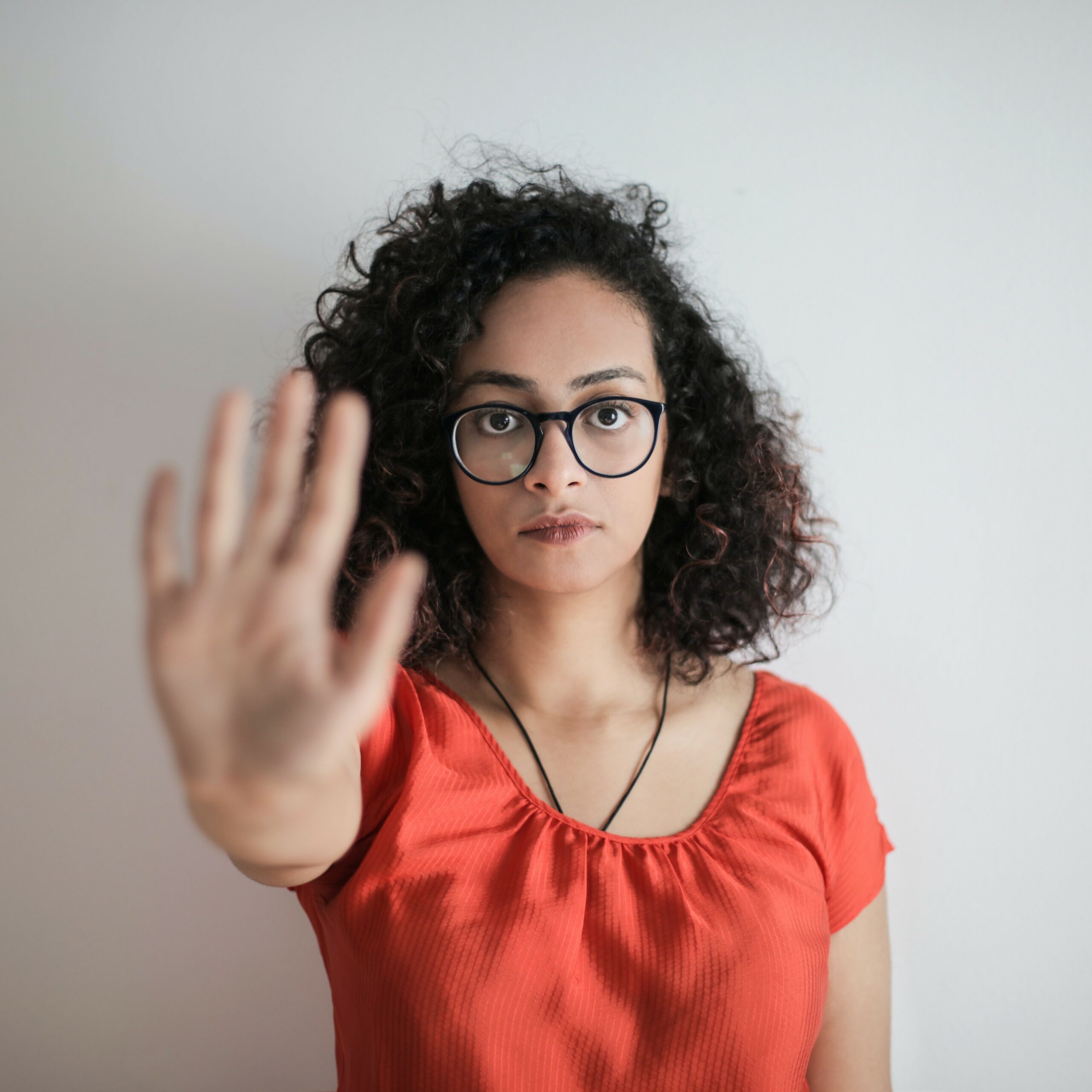 photo of a woman sticking her hand up to the camera.