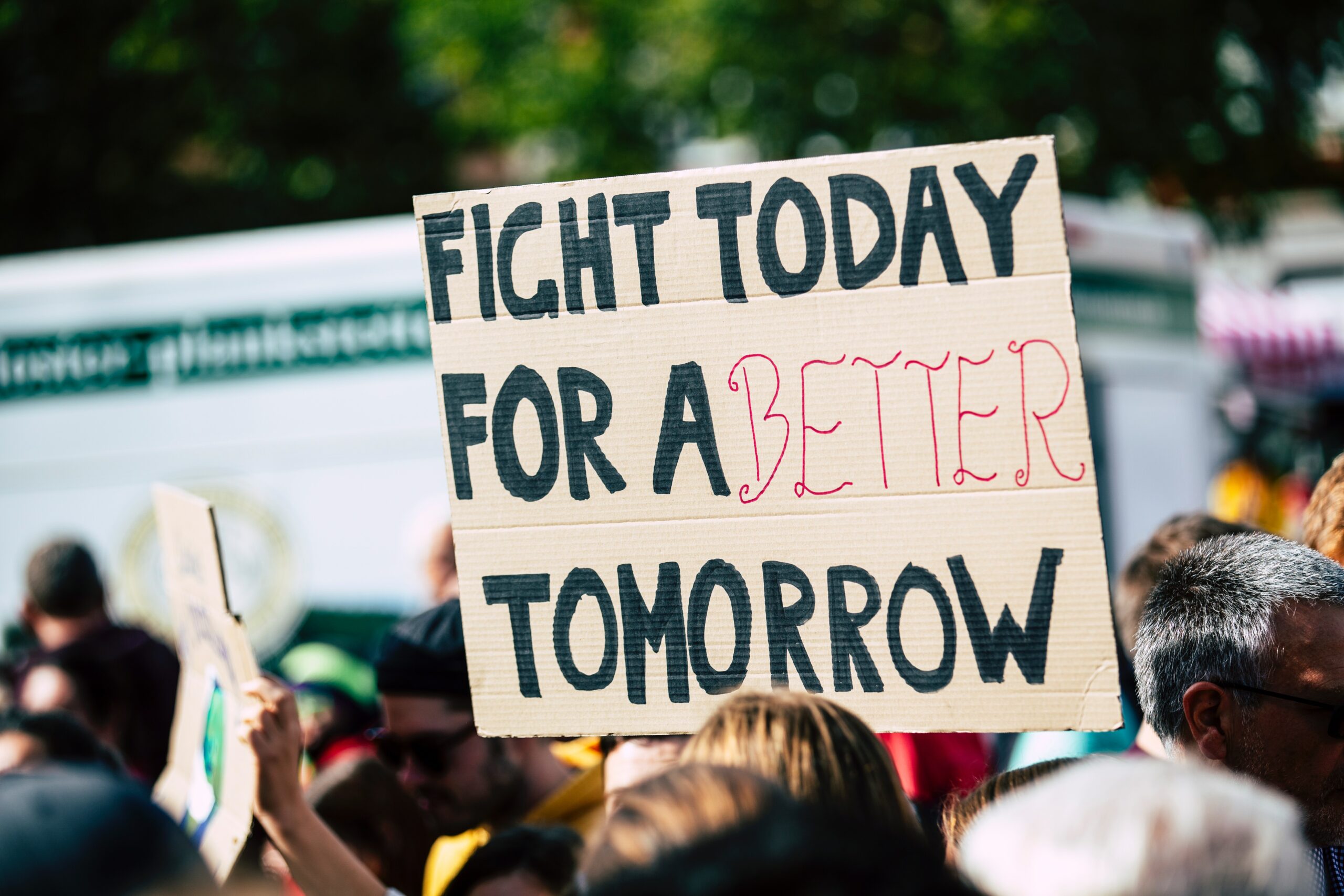 photo of a sign at a protest asking for change.